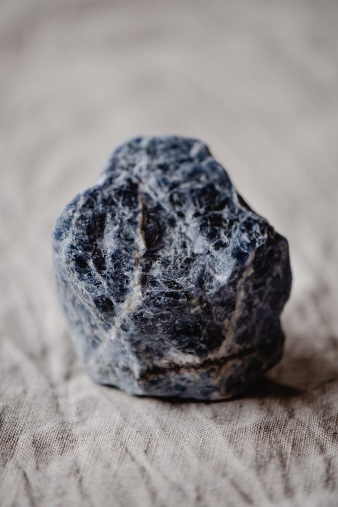 Detailed close-up of a rough sodalite mineral stone, showcasing its intricate texture and natural beauty.