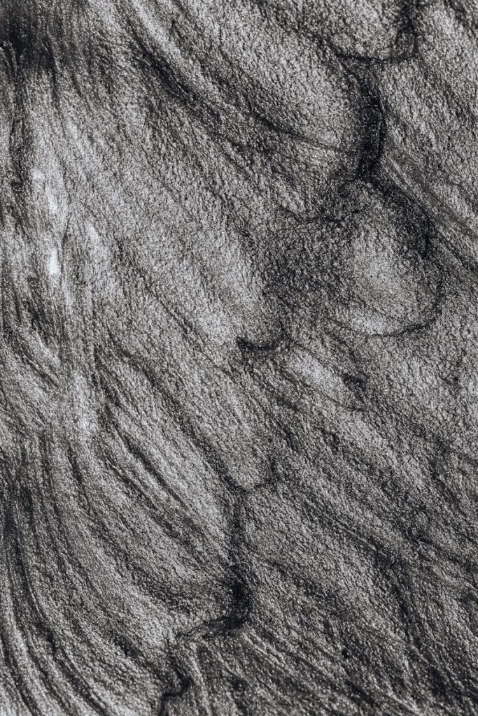 Close-up abstract art with monochrome brushstrokes and textured patterns, creating a dark and elegant visual.